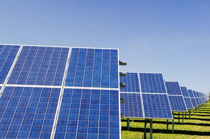 Side-by-side comparison graphic showing monocrystalline (uniform black) vs polycrystalline (blue-speckled) solar panels